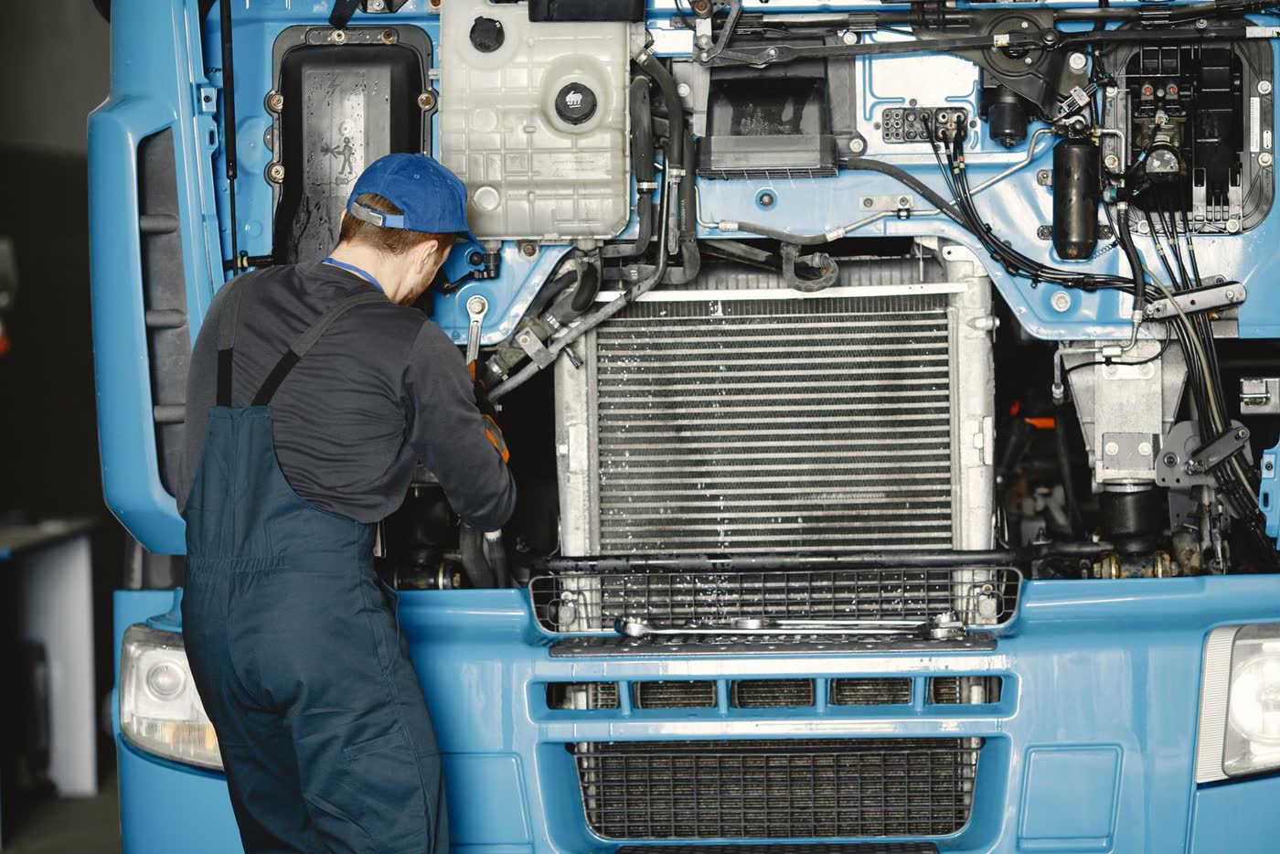 Een monteur werkt aan de motor van een vrachtwagen